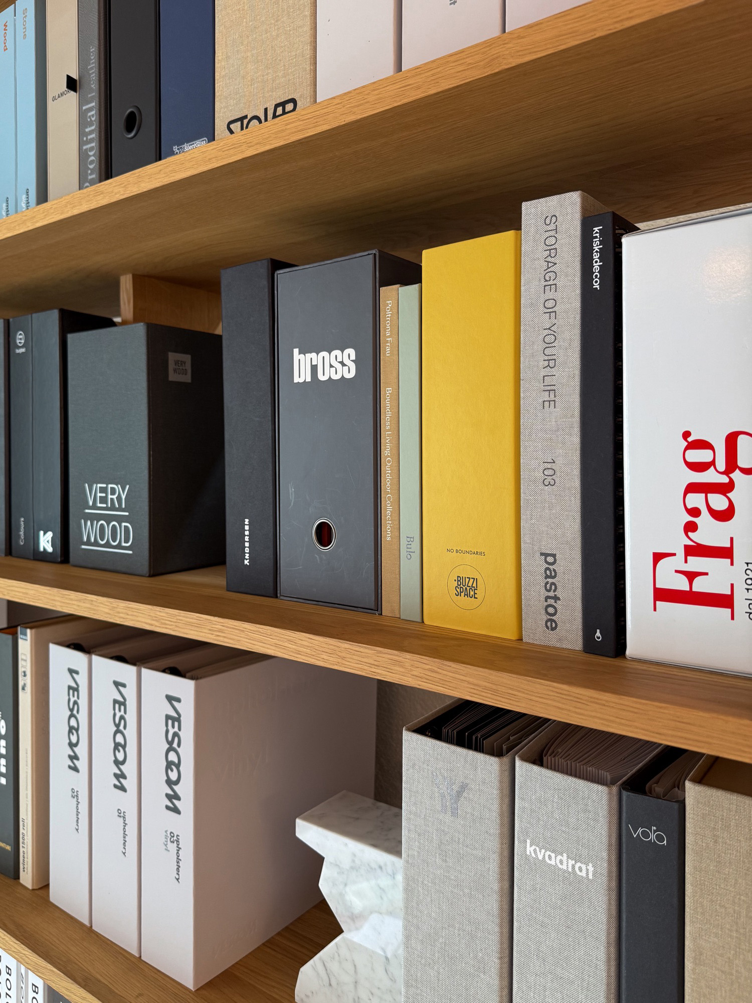 A shelf of brand catalogs and binders, spines facing out.